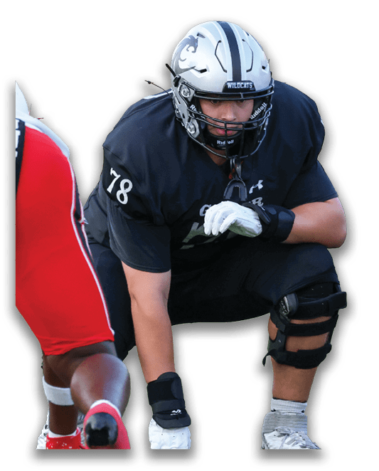 Two people wearing black football uniforms and helmets are engaged in a game or practice, with one person crouching and the other standing. Description generated by AI