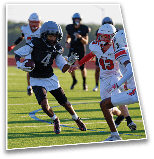 A person wearing a sports uniform is running on a grassy field while holding a football. Description generated by AI
