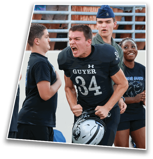 A group of people wearing sports and casual clothing are standing near bleachers with one person in a football jersey yelling passionately while holding a helmet. Description generated by AI