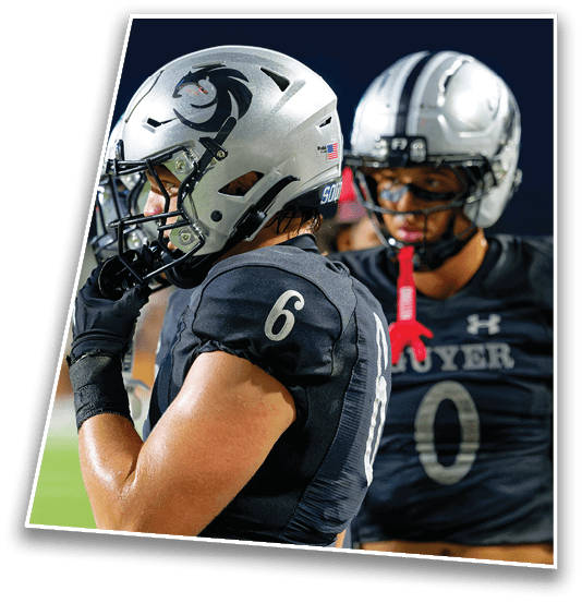 A person wearing a silver football helmet with a black horse logo and an American flag sticker is shown in profile against a dark background. Description generated by AI