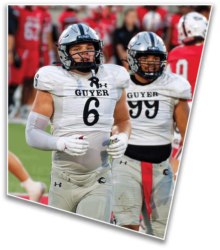A person wearing a Wildcats football helmet and white uniform is on the field with another person in a similar helmet and uniform in the background. Description generated by AI