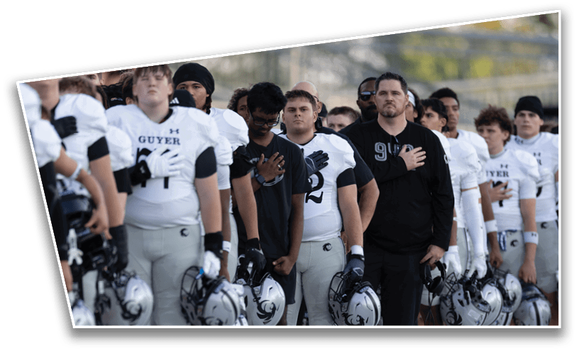 A group of people wearing sports uniforms and casual clothing stand in a line with their hands over their hearts outdoors. Description generated by AI