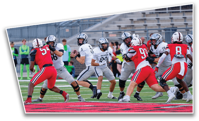Adults in football uniforms are actively engaged in a game on a field with a quarterback preparing to throw the ball while opponents attempt to block. Description generated by AI