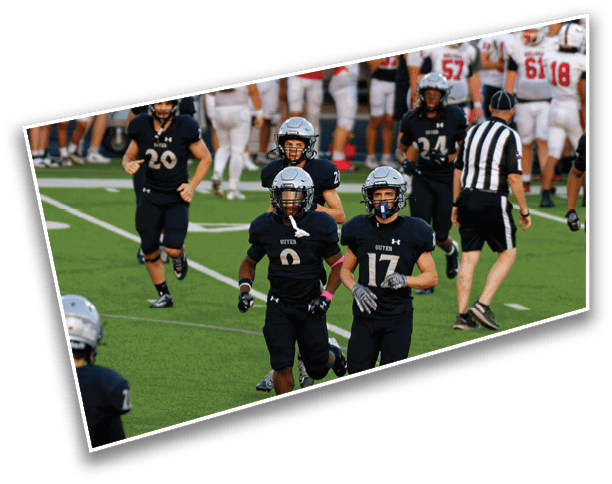 Several people in black football uniforms are walking on a field with a referee and a group of people in white and red uniforms standing in the background. Description generated by AI