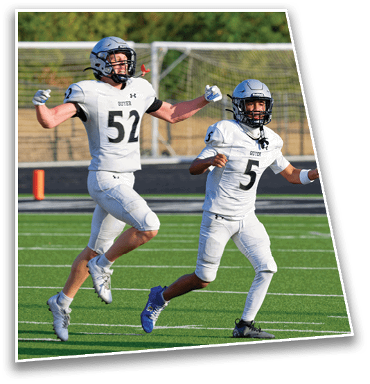 Two people in football uniforms and helmets are celebrating on a football field with one person jumping and the other running. Description generated by AI