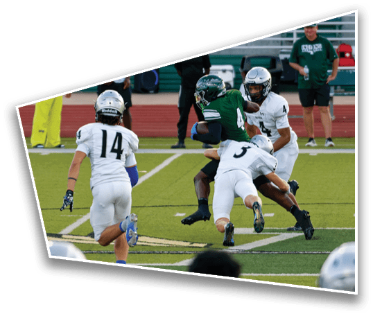 A group of people in football uniforms are actively engaged in a play on a field, with one person in green holding the ball while others in white attempt to tackle or block. Description generated by AI