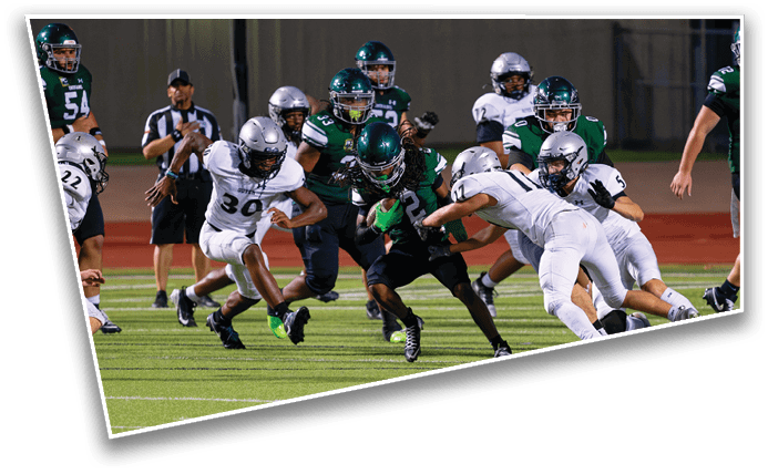 A group of people in football uniforms are actively playing on a field with one person in black running with the ball while others in white attempt to tackle them. Description generated by AI