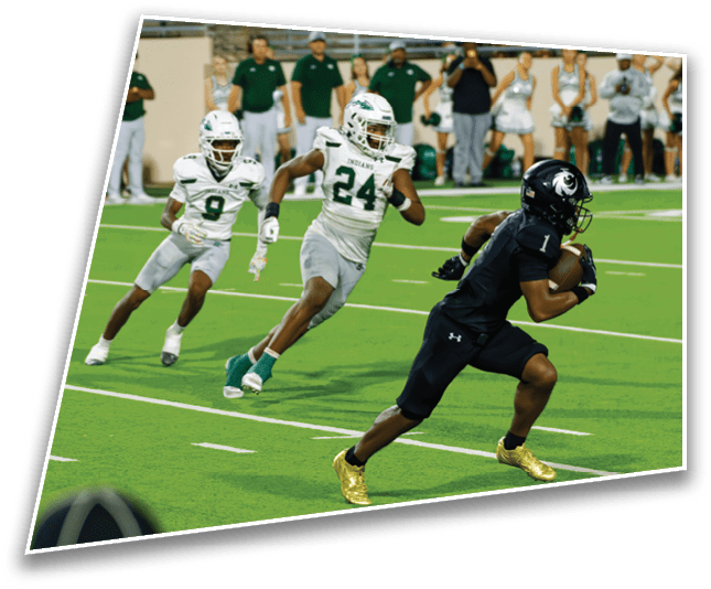 People wearing sports uniforms and cleats are running on a green football field during a game. Description generated by AI