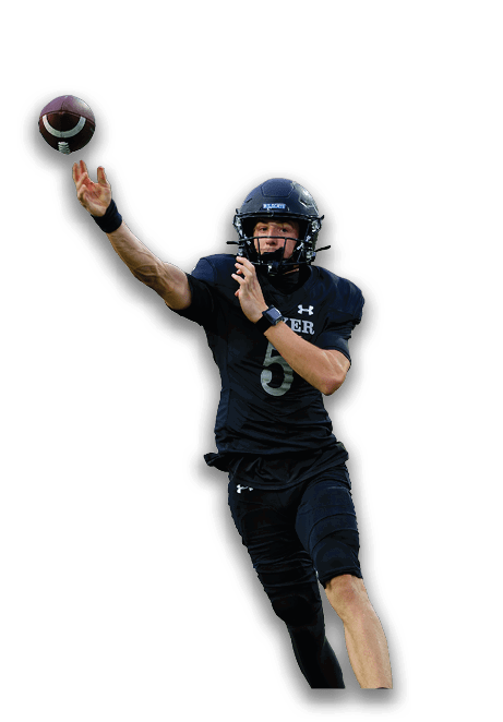 A person wearing a black football uniform and helmet is in motion, appearing to throw a football. Description generated by AI