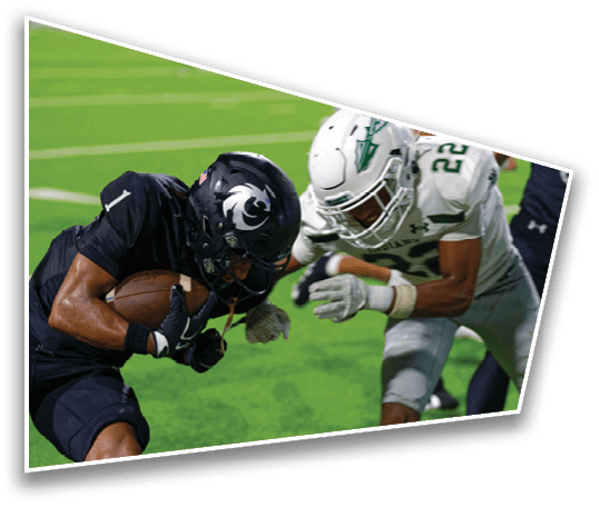 Two people in football uniforms are engaged in a play on a green field, with one person holding the ball tightly while the other reaches out to tackle. Description generated by AI