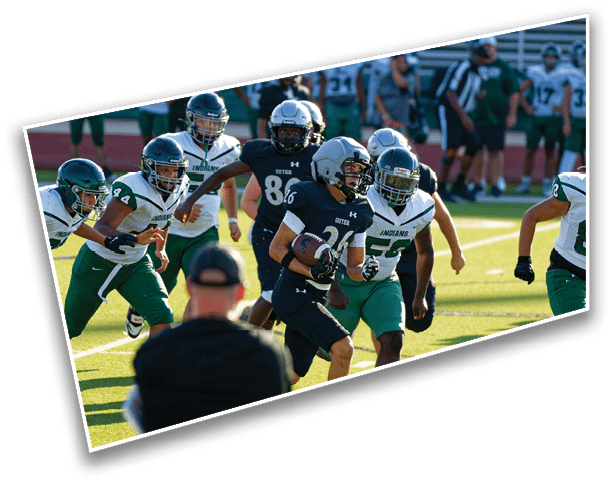 People in football uniforms are actively playing on a field with one person running with the ball while others chase. Description generated by AI