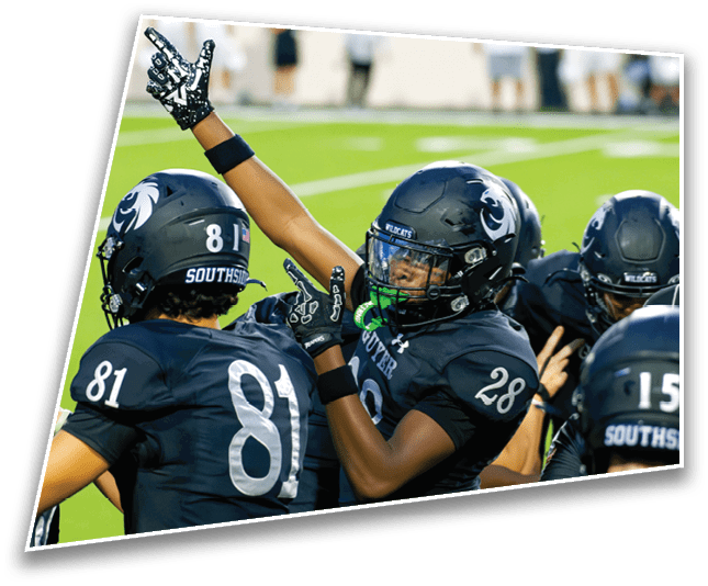 People wearing black football uniforms with helmets are celebrating on a green field. Description generated by AI