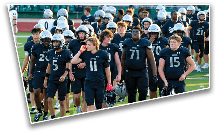 People wearing football uniforms are actively playing on a green field with one person holding the ball while others are running and attempting to tackle. Description generated by AI