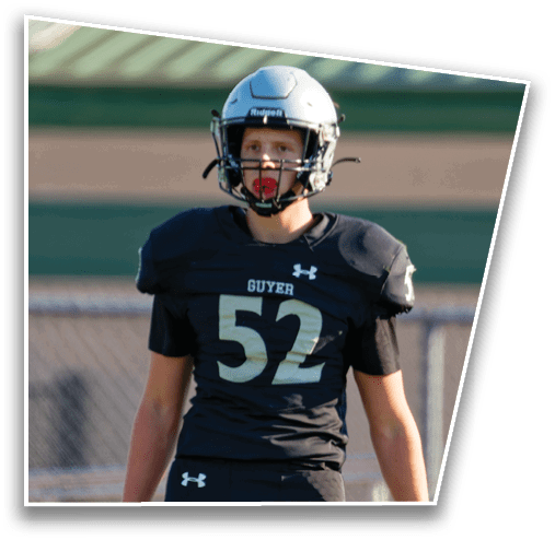 A person wearing a white football helmet with a faceguard is visible against a blurred background with diagonal lines. Description generated by AI