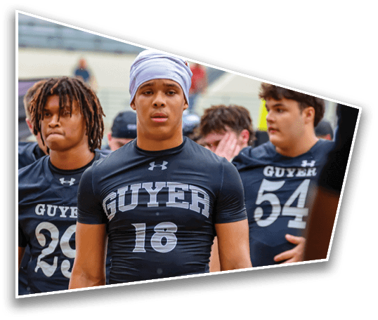 Three people wearing black athletic shirts with “GUYER" and numbers printed on them stand outdoors, appearing focused and serious. Description generated by AI
