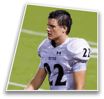 A person with short wet hair wearing a white sports jersey is looking to the side on a green field. Description generated by AI