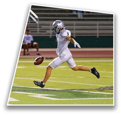 Two people in football uniforms are on a field with one person in white reaching out toward the other person in green. Description generated by AI