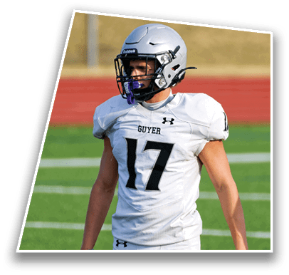 A person wearing a white football uniform with the number 17 and a silver helmet is standing on a green field with a red track in the background. Description generated by AI