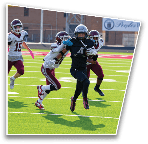 People wearing sports uniforms are running on a green field with white yard lines. Description generated by AI