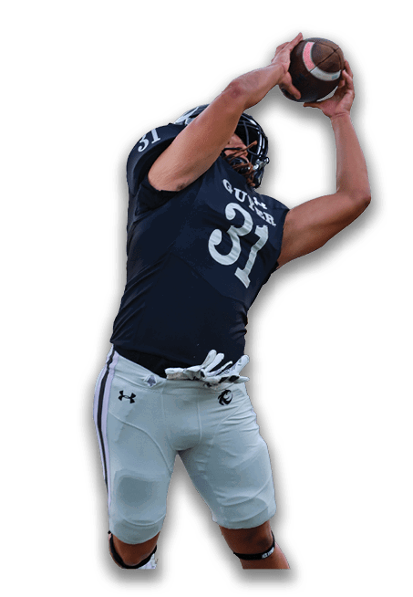 A person wearing a dark sports jersey and light pants is jumping and reaching up to catch a football. Description generated by AI