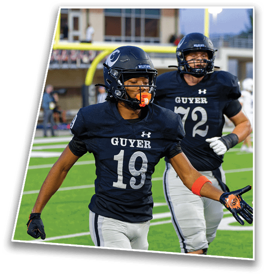 Two people wearing football uniforms with helmets and gloves are on a field, one with the number 19 and the other with the number 72, both appearing to be engaged in the game. Description generated by AI
