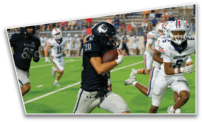 People in football uniforms are actively running on a green field during a game, with one person holding the ball and others chasing. Description generated by AI