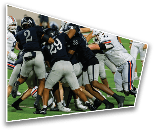 A group of football players in dark and white uniforms are engaged in a close, intense play on a green field. Description generated by AI