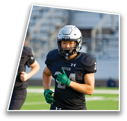 Two people in black football uniforms with green gloves are running on a field. Description generated by AI
