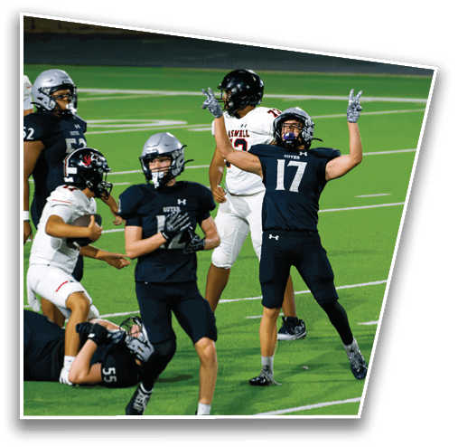 Several people wearing football uniforms are actively playing on a green field with white yard lines. Description generated by AI