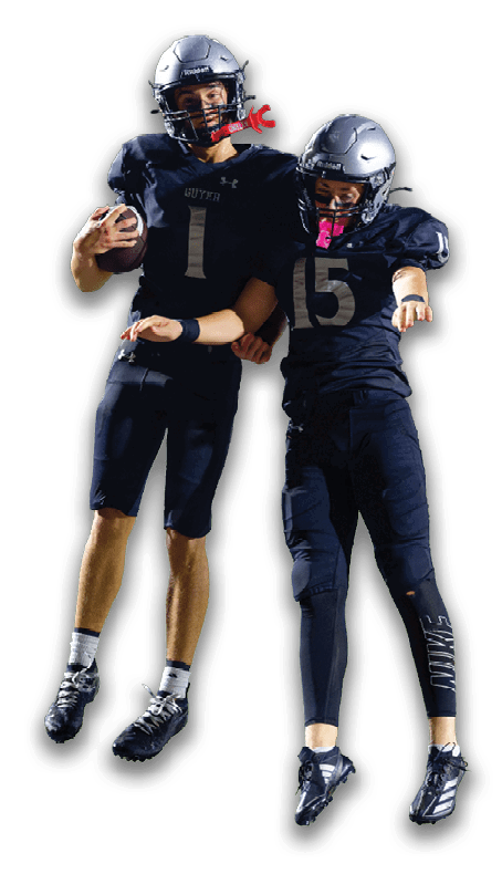 Two people in dark football uniforms and helmets are jumping together while a third person in a white football uniform stands nearby. Description generated by AI