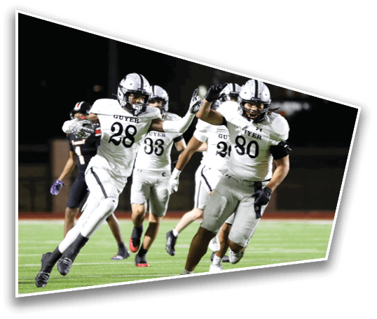 Several people in white football uniforms are celebrating on a field at night. Description generated by AI