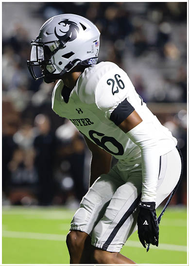 A person wearing a white football helmet with a black lion logo and a white football jersey with the number 26 is looking to the left. Description generated by AI