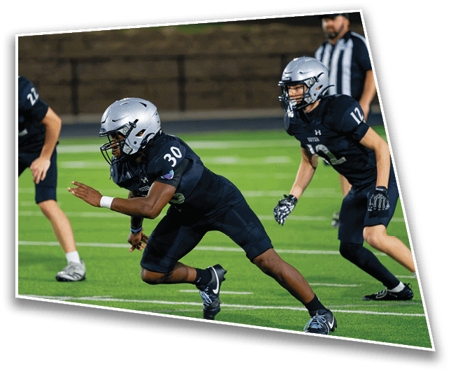 Three people in football uniforms and helmets are actively running on a green field during a game or practice. Description generated by AI