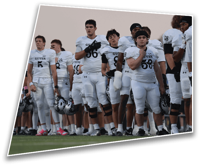 A group of people wearing white sports jerseys with the word “GUYER" stand closely together against a plain sky background. Description generated by AI