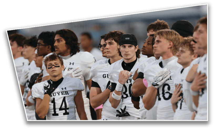 A group of people wearing white sports uniforms stand closely together with serious expressions, some holding their hands over their chests. Description generated by AI