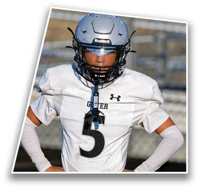 A person wearing a silver football helmet with a clear visor and a white Under Armour jersey is looking directly ahead. Description generated by AI