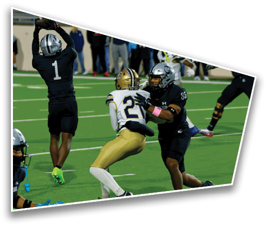 People wearing football uniforms are actively engaged in a play on a green field with one person in white and gold being tackled by two others in black and silver. Description generated by AI