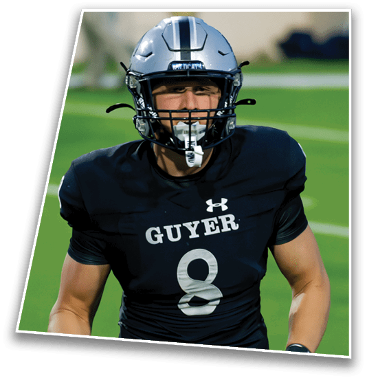 A person wearing a football helmet and black sports jersey is on a green field. Description generated by AI