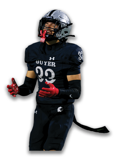 A person wearing a football uniform with the number 33 and the word Guyer on the jersey is standing with arms slightly raised and wearing red gloves and a silver helmet. Description generated by AI