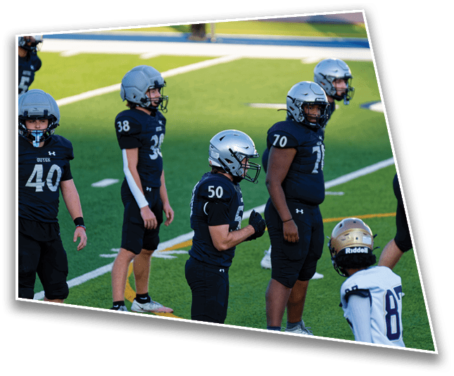 Several people wearing football uniforms and helmets stand on a green field, appearing to prepare for a play. Description generated by AI