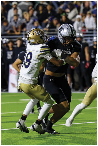 A person wearing a white and gold football uniform with the number nine is running on a green field during a game with a crowd and other players in the background. Description generated by AI