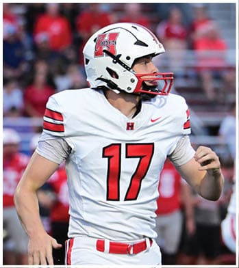 A person wearing a white football helmet with a red and black Chargers logo on the side. Description generated by AI