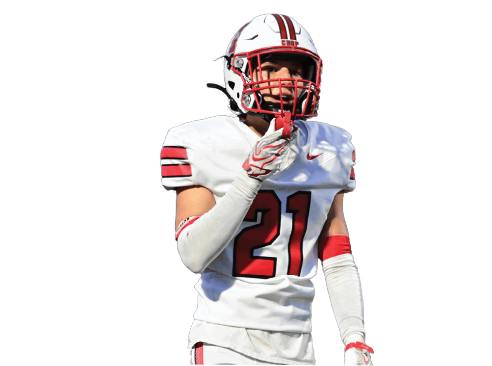 A person wearing a white football uniform with the number 21 is standing and pointing forward. Description generated by AI