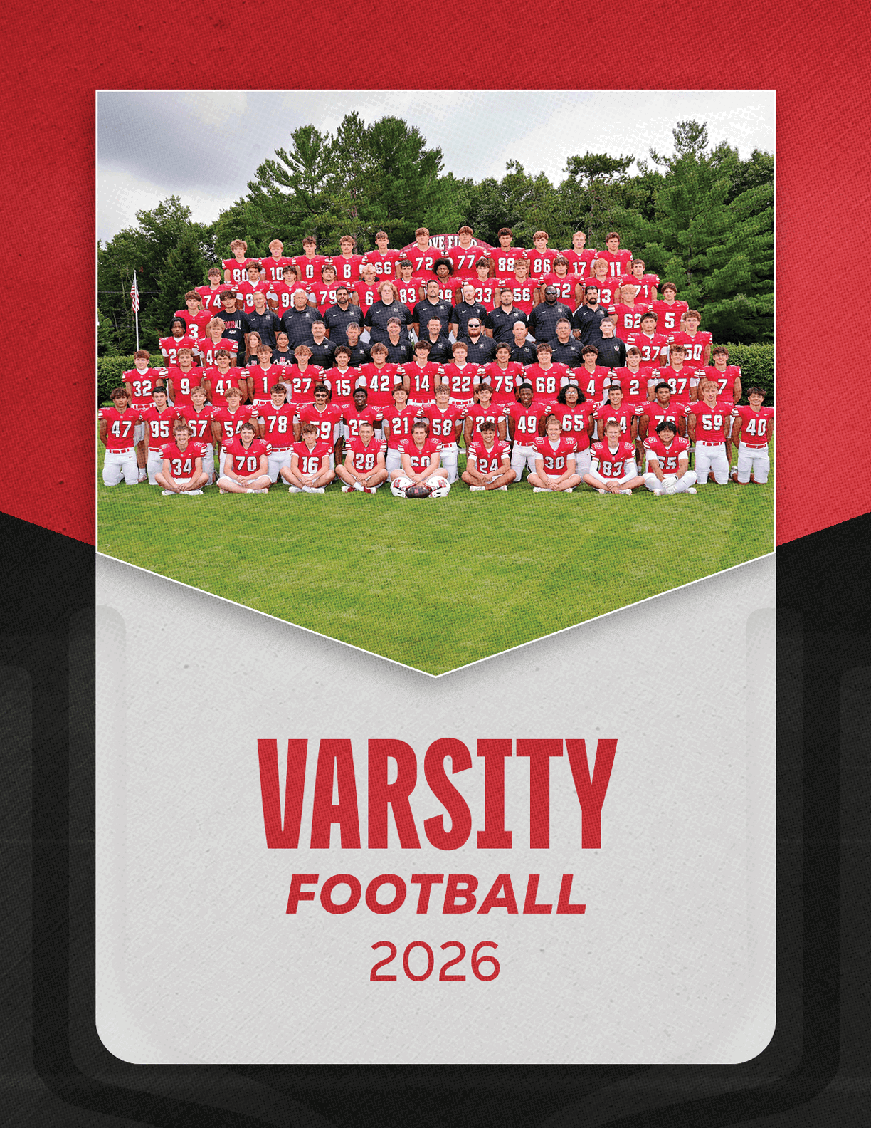 A large group of people wearing red football uniforms and black shirts pose together on grass with trees in the background above the text varsity football 2026. Description generated by AI