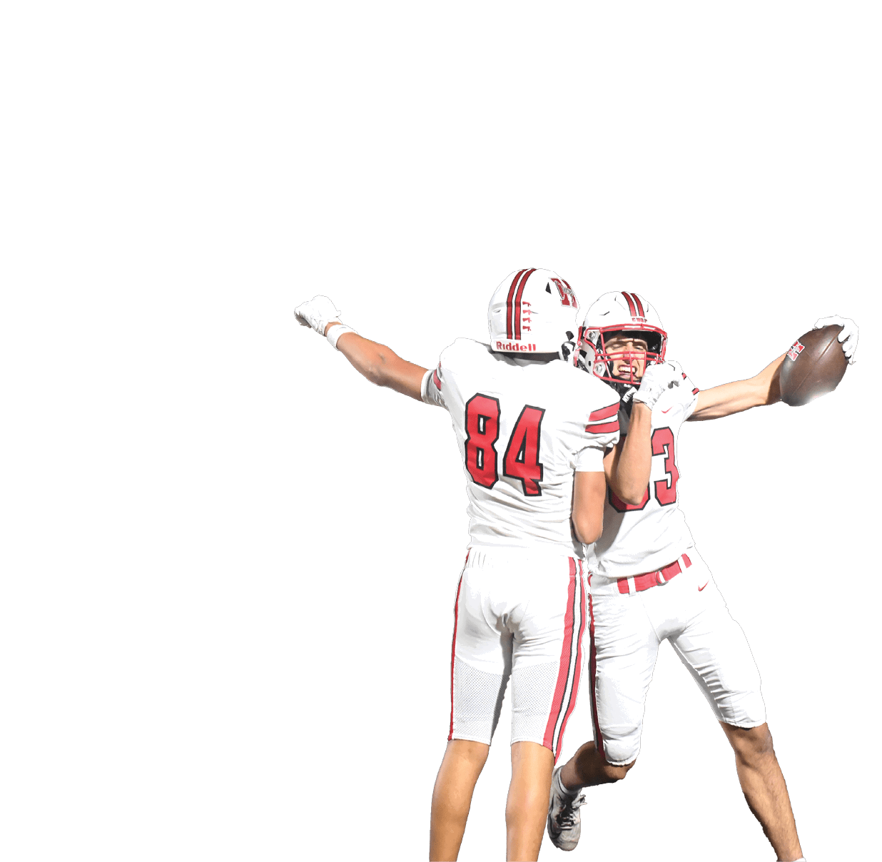 Two people in white football uniforms with red stripes and numbers are celebrating on a field under bright lights. Description generated by AI