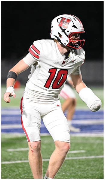 A person wearing a white football uniform with the number 10 is standing on a field at night, appearing to be in motion. Description generated by AI