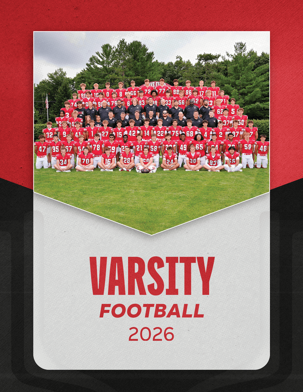 A large group of people wearing red football uniforms and black shirts pose together on grass with trees in the background above the text varsity football 2026. Description generated by AI