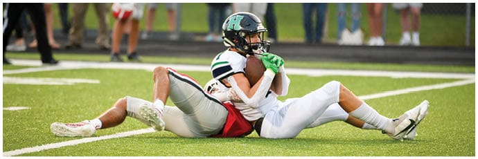 A football player wearing a blue and white uniform. Description generated by AI