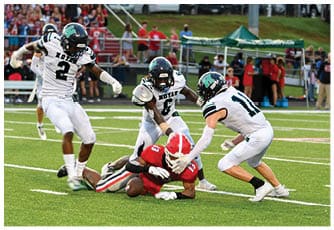 A group of football players on a field. Description generated by AI