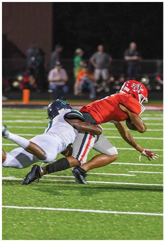 A football player catching a ball. Description generated by AI